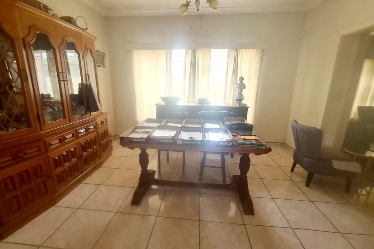 A dining room featuring tiled flooring and a central ceiling light fixture, providing a functional space for meals.