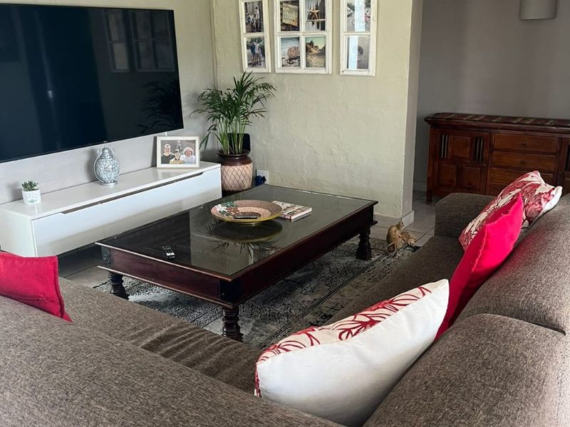 A comfortable living room featuring tiled flooring and a neutral wall finish, providing a functional space for relaxation and entertainment.
