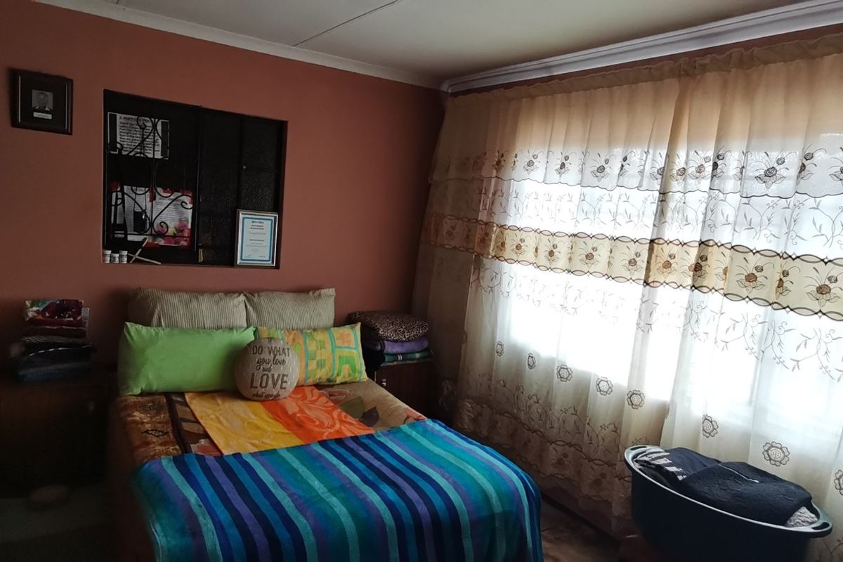 A bedroom featuring a built-in wardrobe and an internal window, providing a functional space with standard finishes.