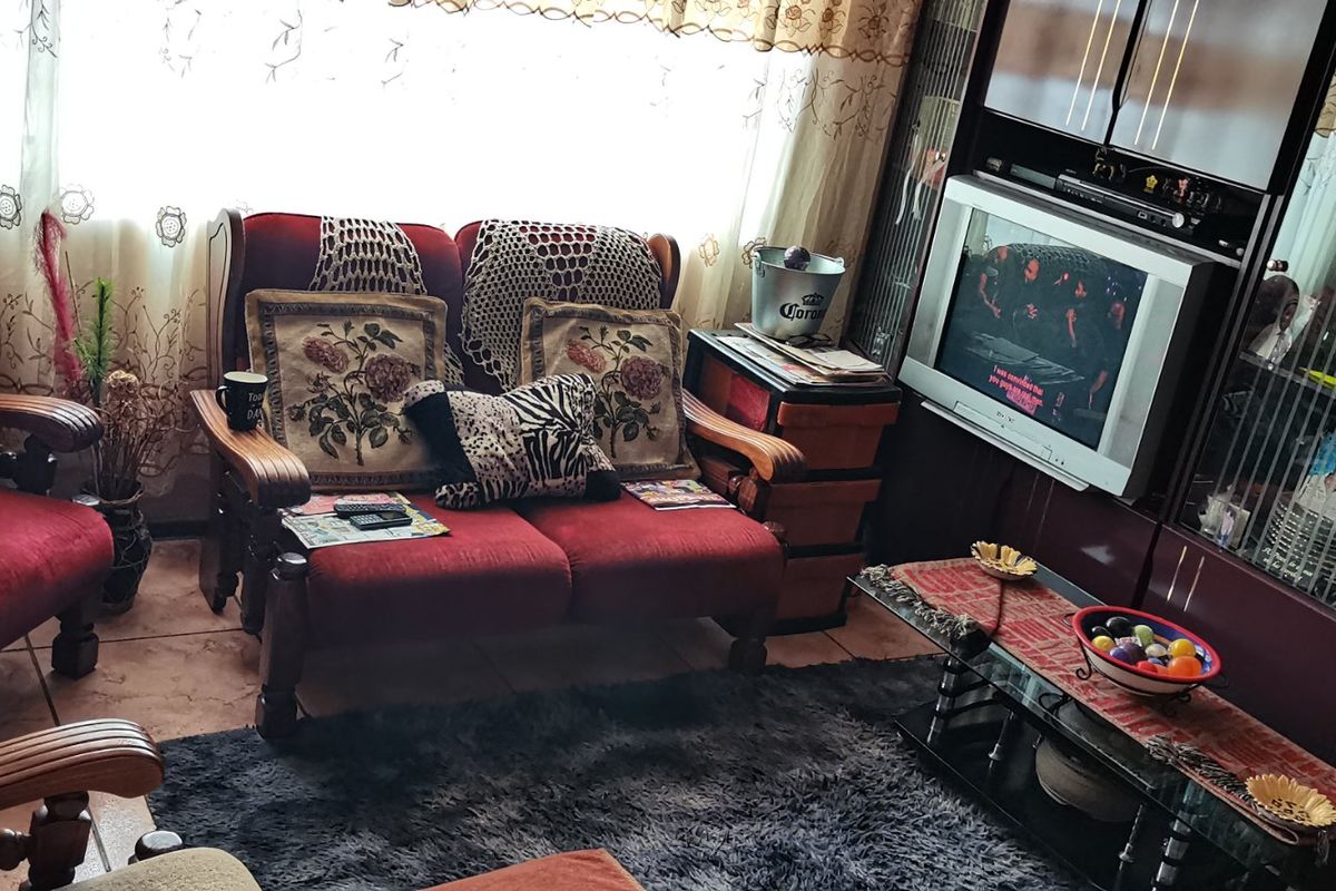 A cozy living room featuring tiled flooring and integrated built-in display cabinetry, providing a functional space for relaxation and storage.