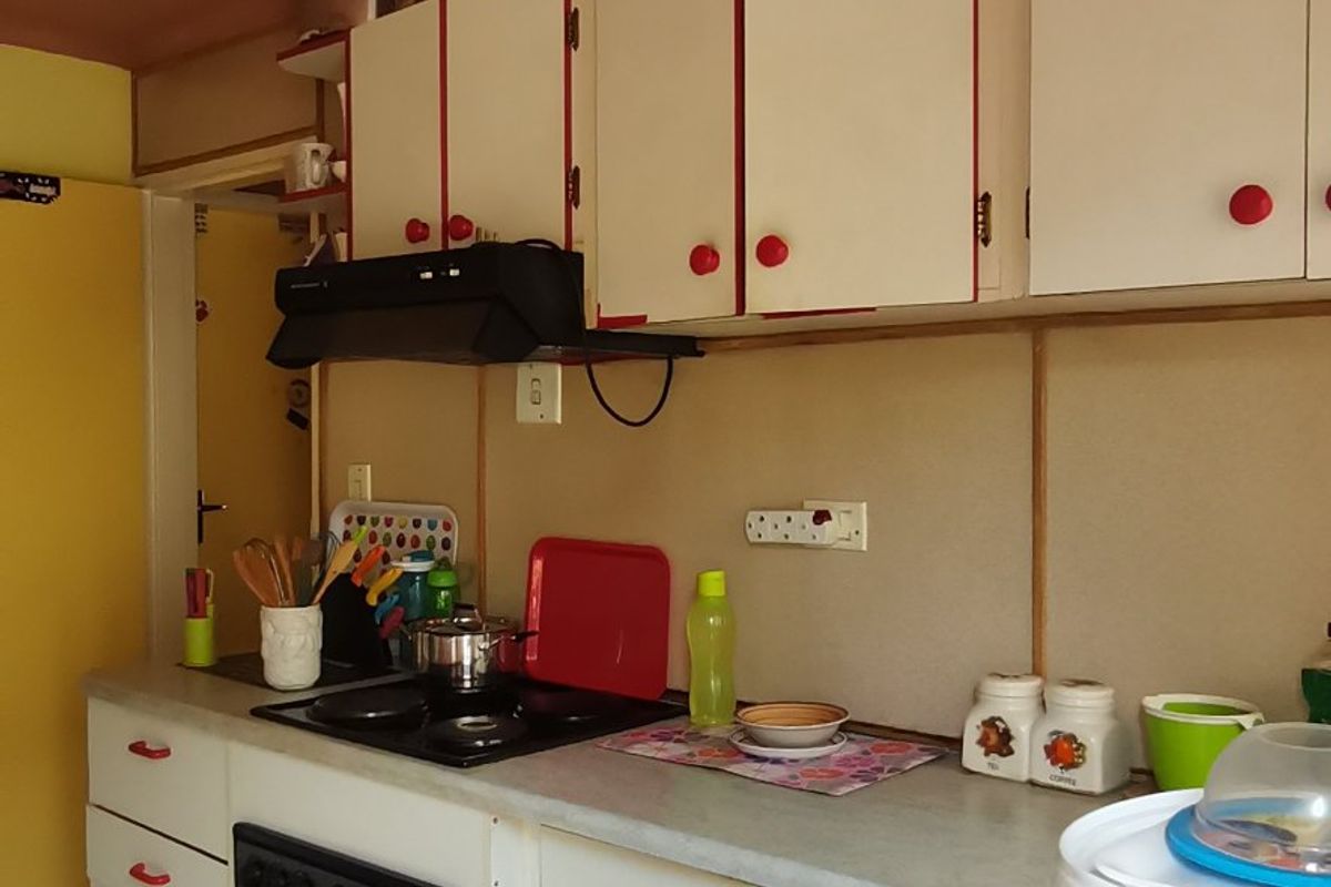 A functional kitchen featuring built-in cabinetry, laminate countertops, and integrated cooking appliances, offering potential for modernization and aesthetic updates.