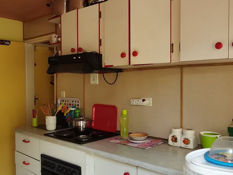 A functional kitchen featuring built-in cabinetry, laminate countertops, and integrated cooking appliances, offering potential for modernization and aesthetic updates.