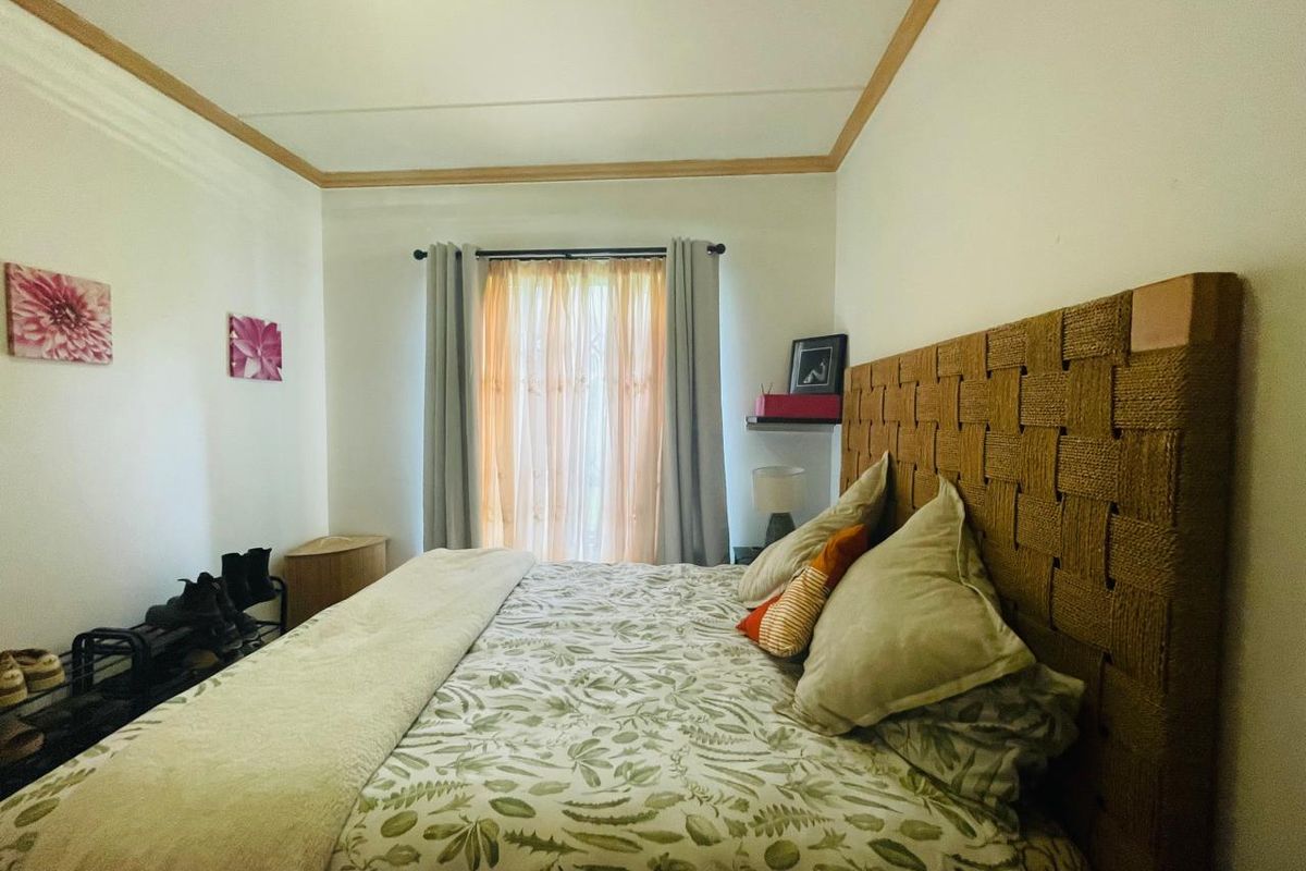 A cozy bedroom featuring crown molding and a window with installed curtain rods, providing a functional and comfortable sleeping space.