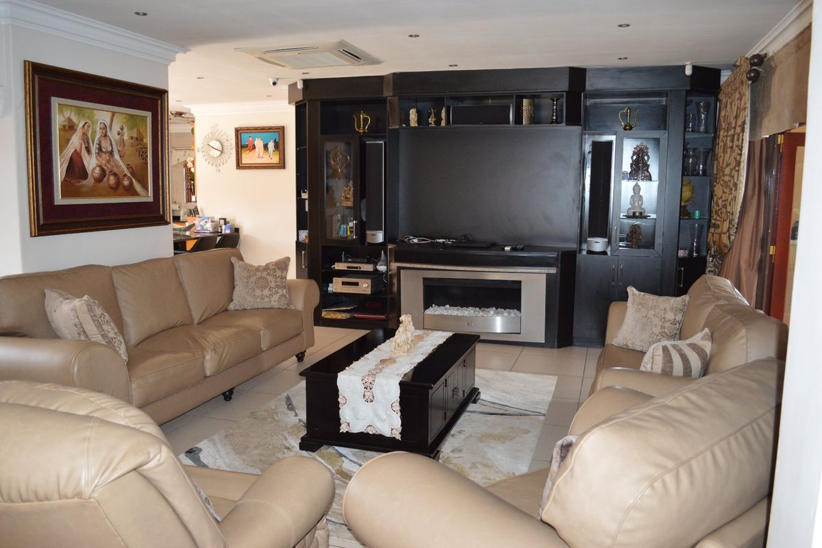 Spacious living room featuring built-in dark cabinetry, a modern electric fireplace, recessed ceiling lighting, and tiled flooring.