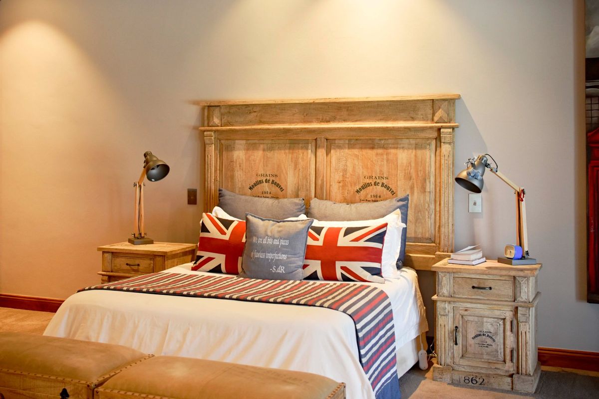 A well-maintained bedroom featuring neutral wall tones, recessed ceiling lighting, and classic timber skirting boards.