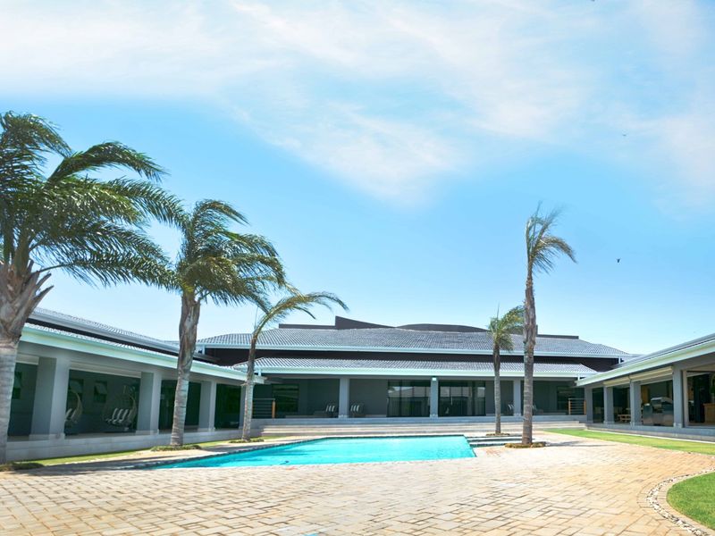 Spacious outdoor entertainment area featuring a large swimming pool, expansive paved patio, and covered verandas surrounding the central courtyard.