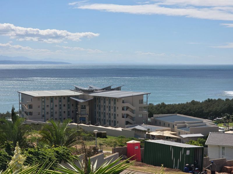 A scenic elevated view overlooking the ocean and surrounding coastal residential development.