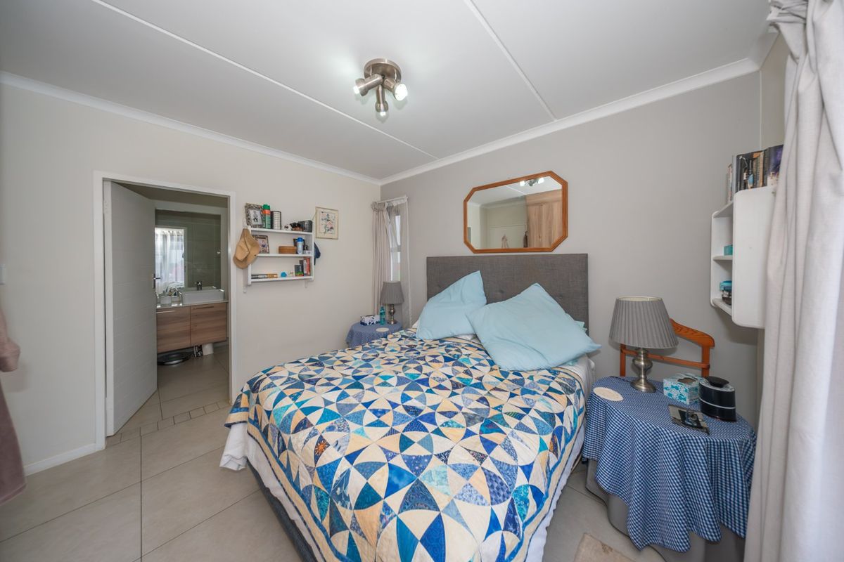 A well-lit bedroom featuring tiled flooring and direct access to an en-suite bathroom, providing a functional and comfortable living space.