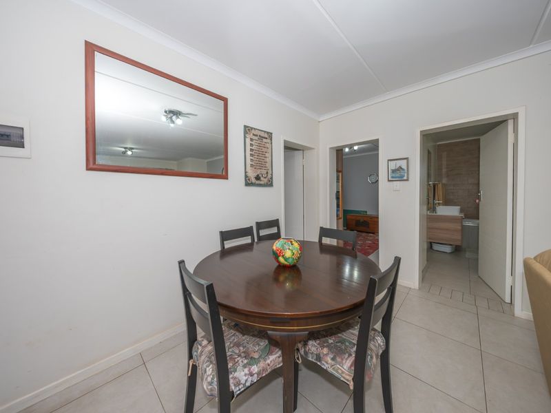 A dining area featuring tiled flooring and coved ceilings, providing access to adjacent rooms and a bathroom.