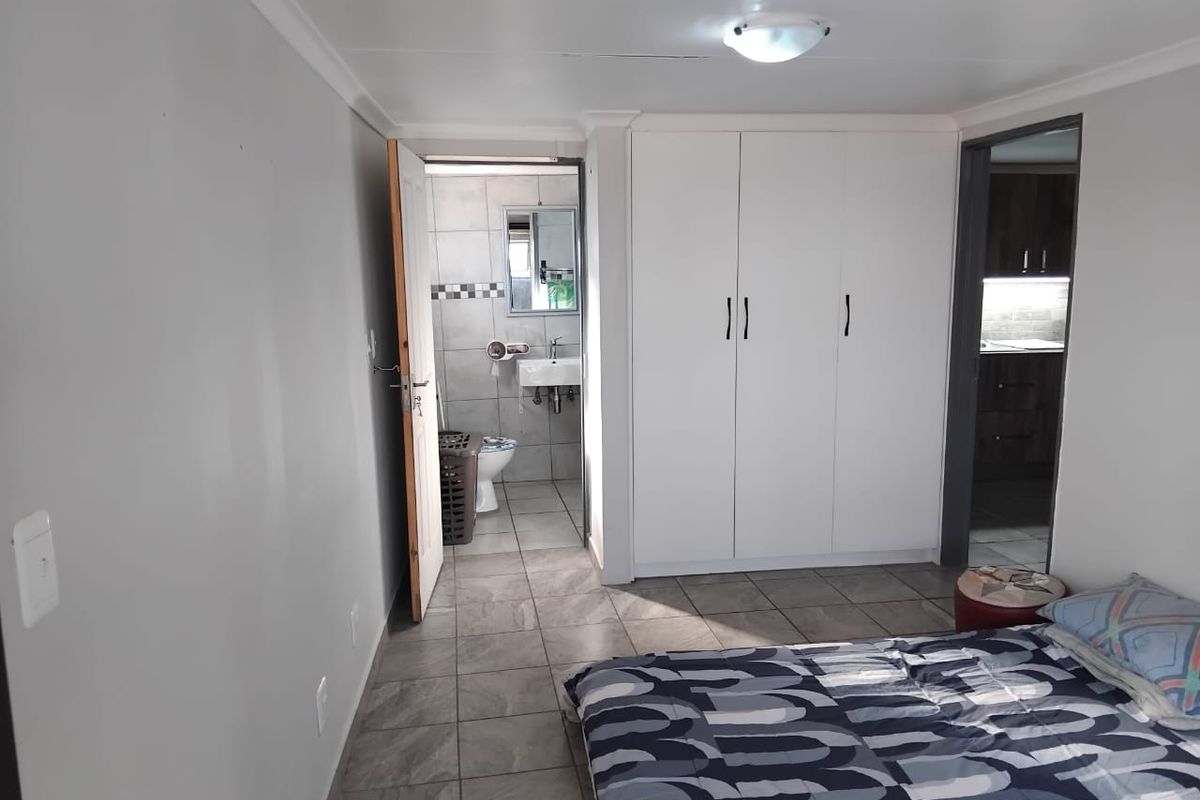 Bedroom featuring tiled flooring, a built-in wardrobe, and direct access to an en-suite bathroom.