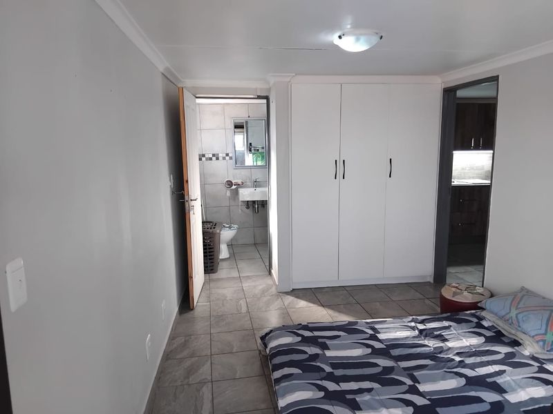 Bedroom featuring tiled flooring, a built-in wardrobe, and direct access to an en-suite bathroom.