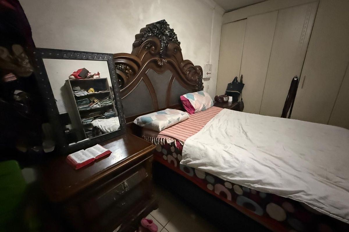 A bedroom featuring built-in wardrobe cabinetry and tiled flooring.