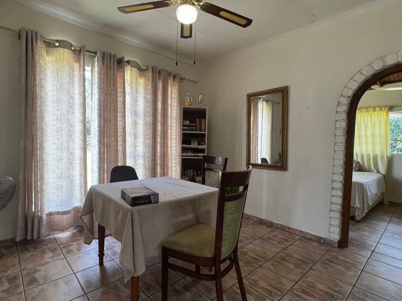 Dining area featuring tiled flooring, a ceiling fan, and a distinctive brick archway leading to an adjacent room.