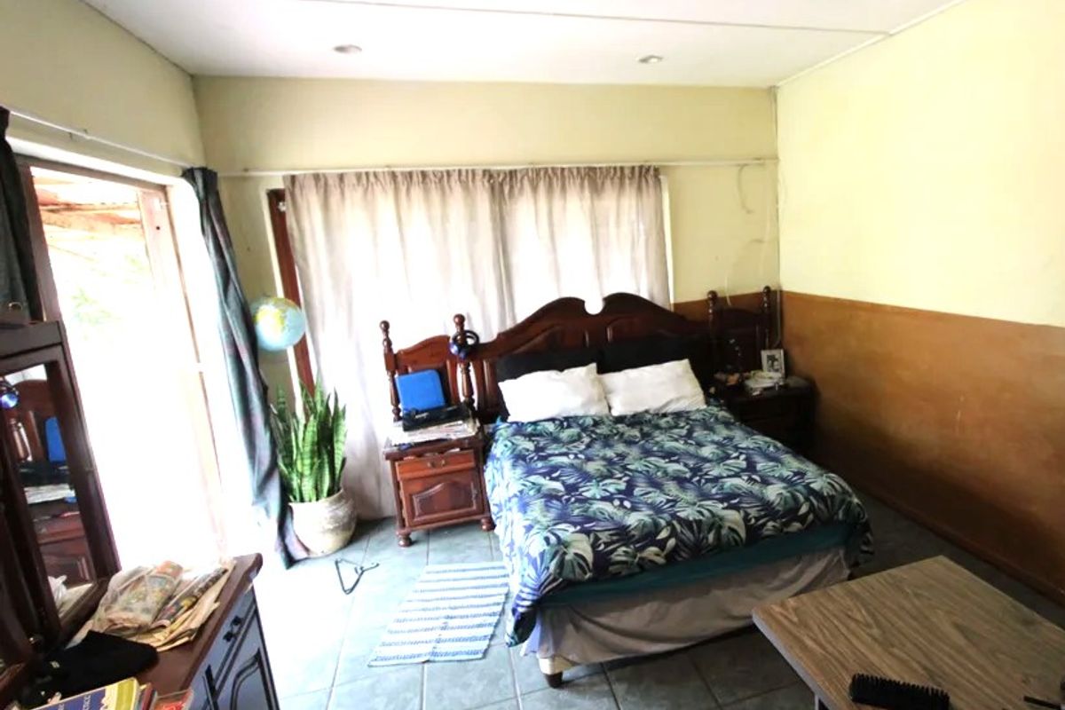 A bedroom featuring tiled flooring, recessed lighting, and direct access to an outdoor area through a sliding glass door.