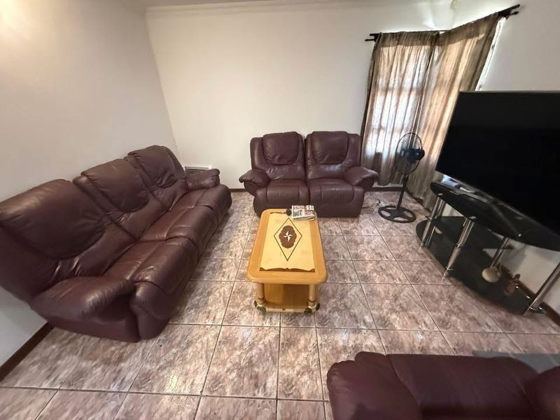 A living room featuring tiled flooring and window treatments, providing a functional space for relaxation.