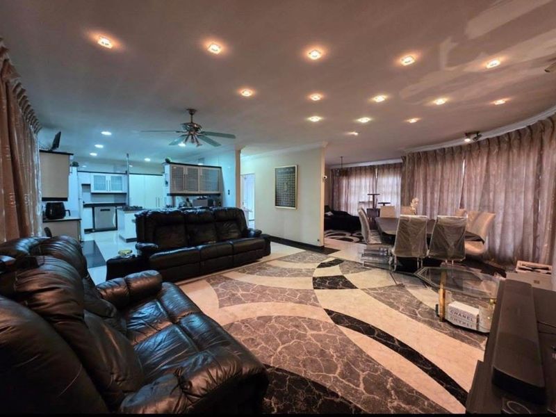 Spacious open-plan living and dining area featuring recessed lighting, decorative tiled flooring, and an integrated kitchen space.