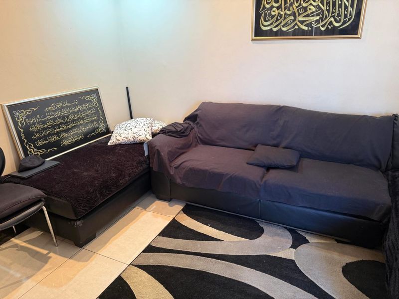 A living room area featuring neutral wall finishes and tiled flooring, providing a functional space for relaxation.