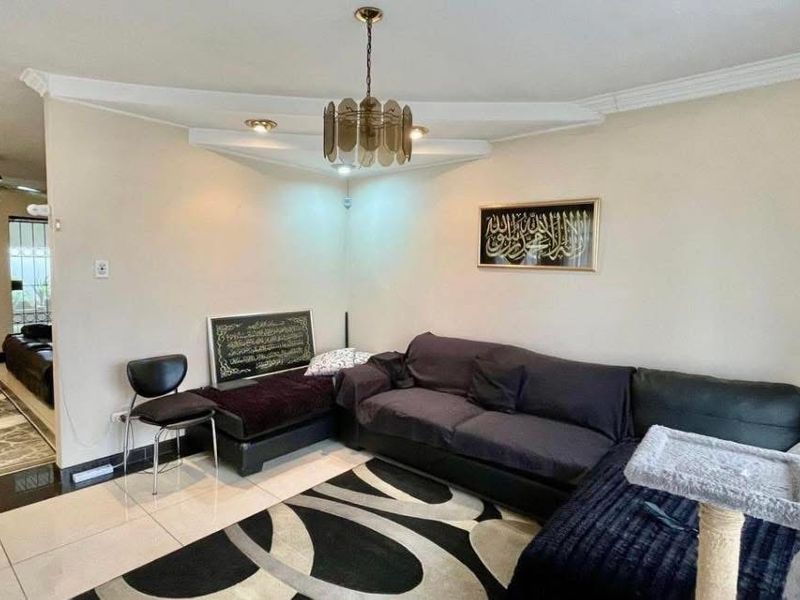 A living room featuring tiled flooring, cove lighting, and a ceiling fan, providing a functional and open living space.