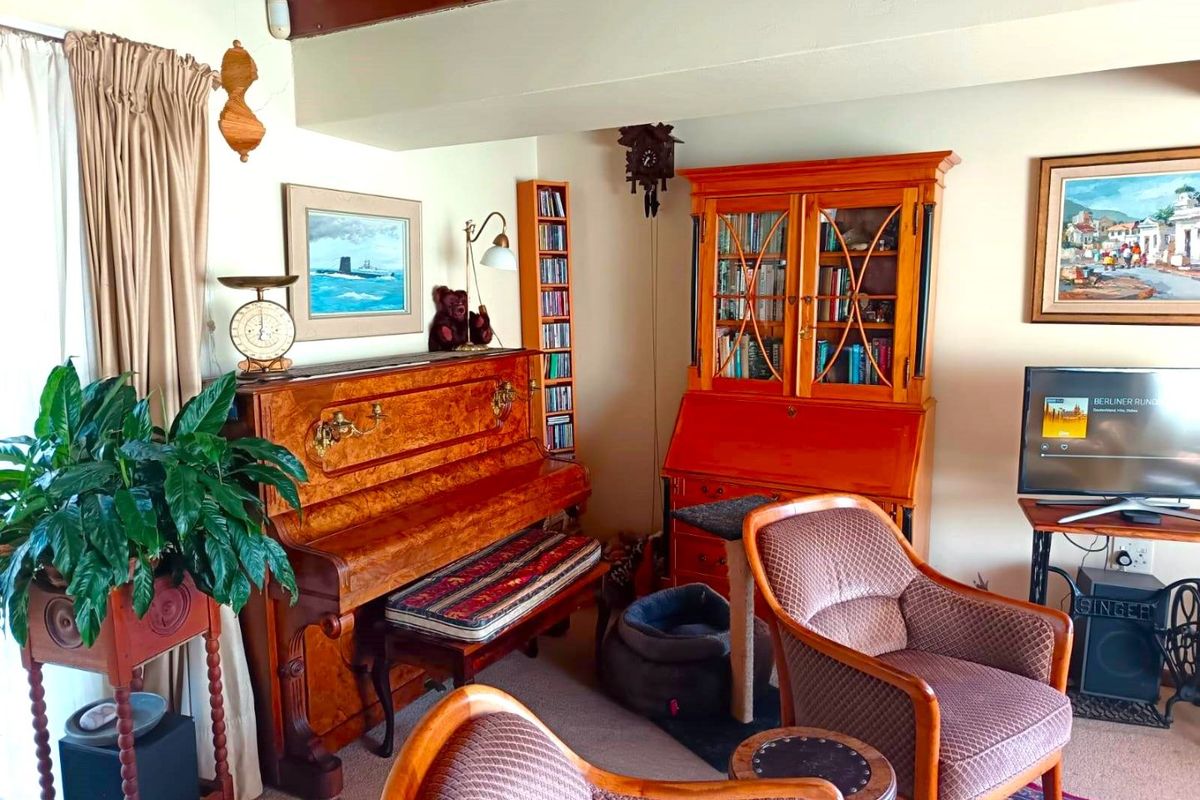 A cozy living room featuring exposed timber ceiling beams and neutral wall finishes, providing a comfortable and traditional living space.