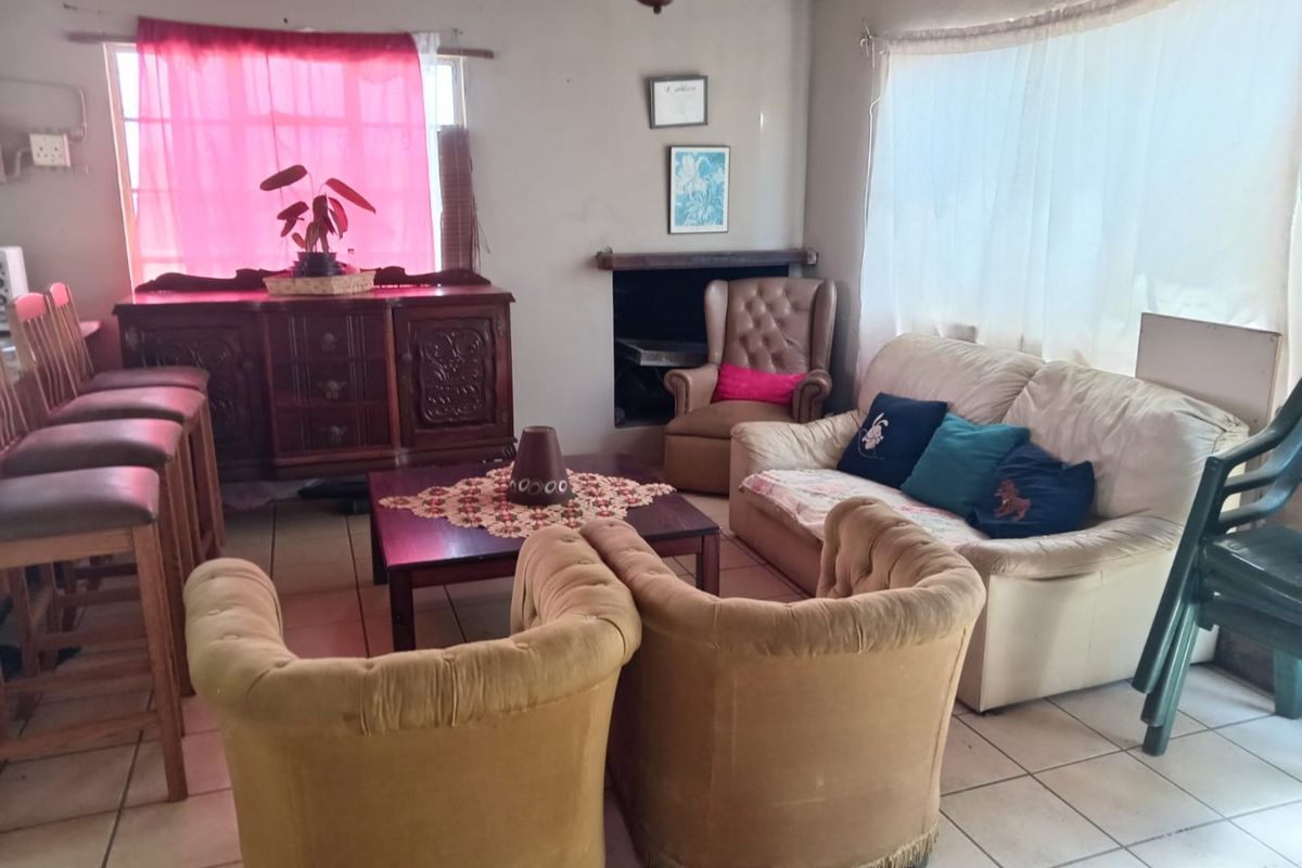A living room featuring tiled flooring and a built-in fireplace, offering a functional space with potential for modernization and aesthetic updates.
