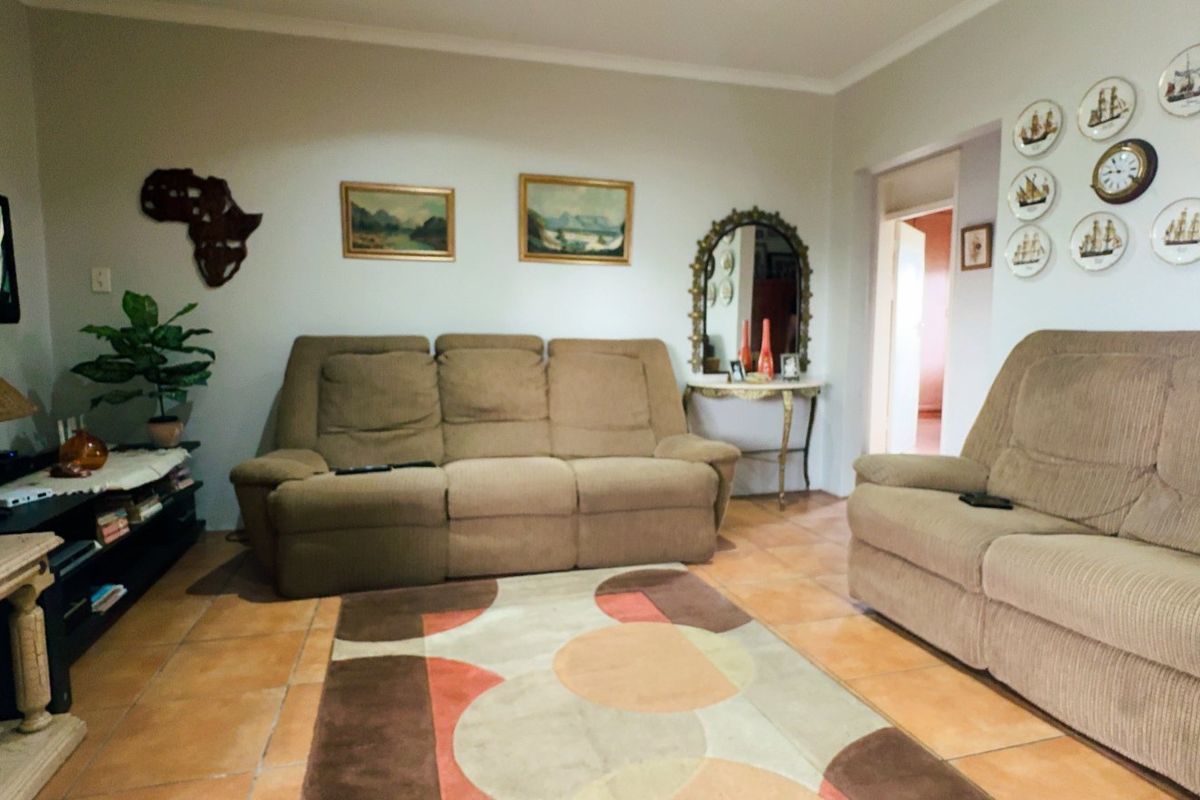 A comfortable living room featuring ceramic tile flooring and coved ceiling cornices, providing a functional and well-maintained space for relaxation.