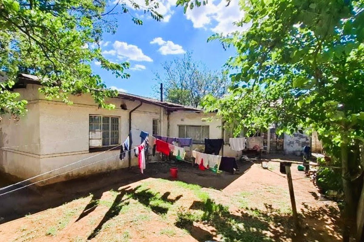 Rear view of the property showing the exterior facade, garden area, and boundary walling.
