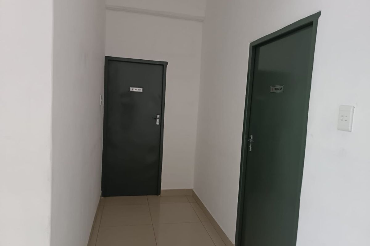 A functional hallway area featuring tiled flooring and access doors to separate male and female restroom facilities.