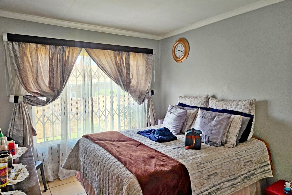 A bedroom featuring tiled flooring and a security gate installed on the window.