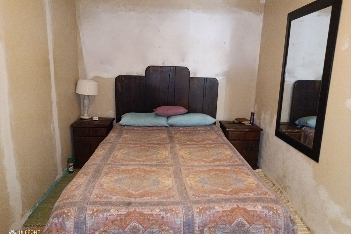 A bedroom featuring unfinished wall surfaces requiring plastering and painting to complete the room's aesthetic.