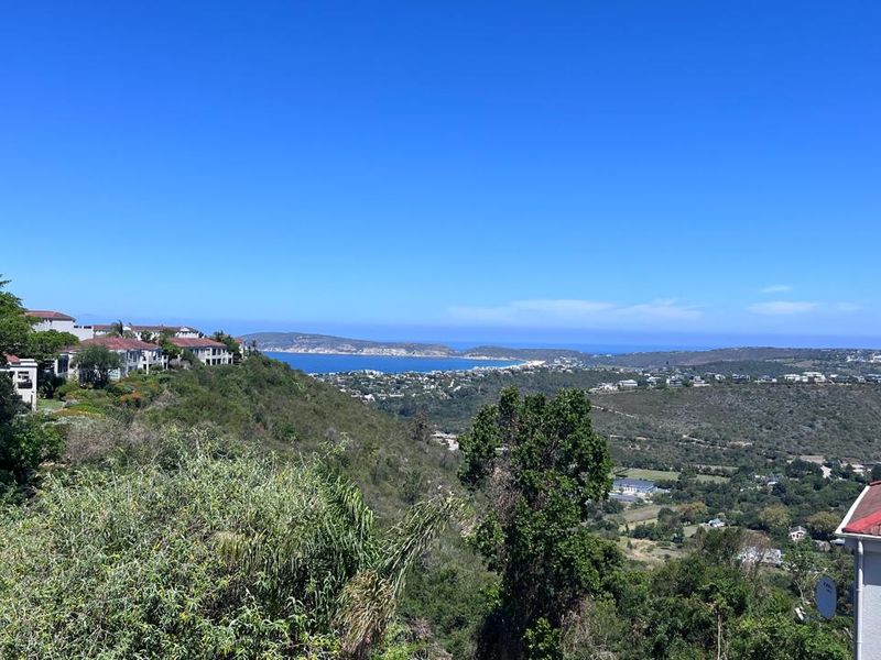 A scenic elevated view overlooking the surrounding coastal landscape, hills, and distant ocean bay.