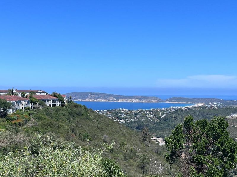 A scenic elevated view overlooking the coastal landscape, bay, and surrounding residential estate.
