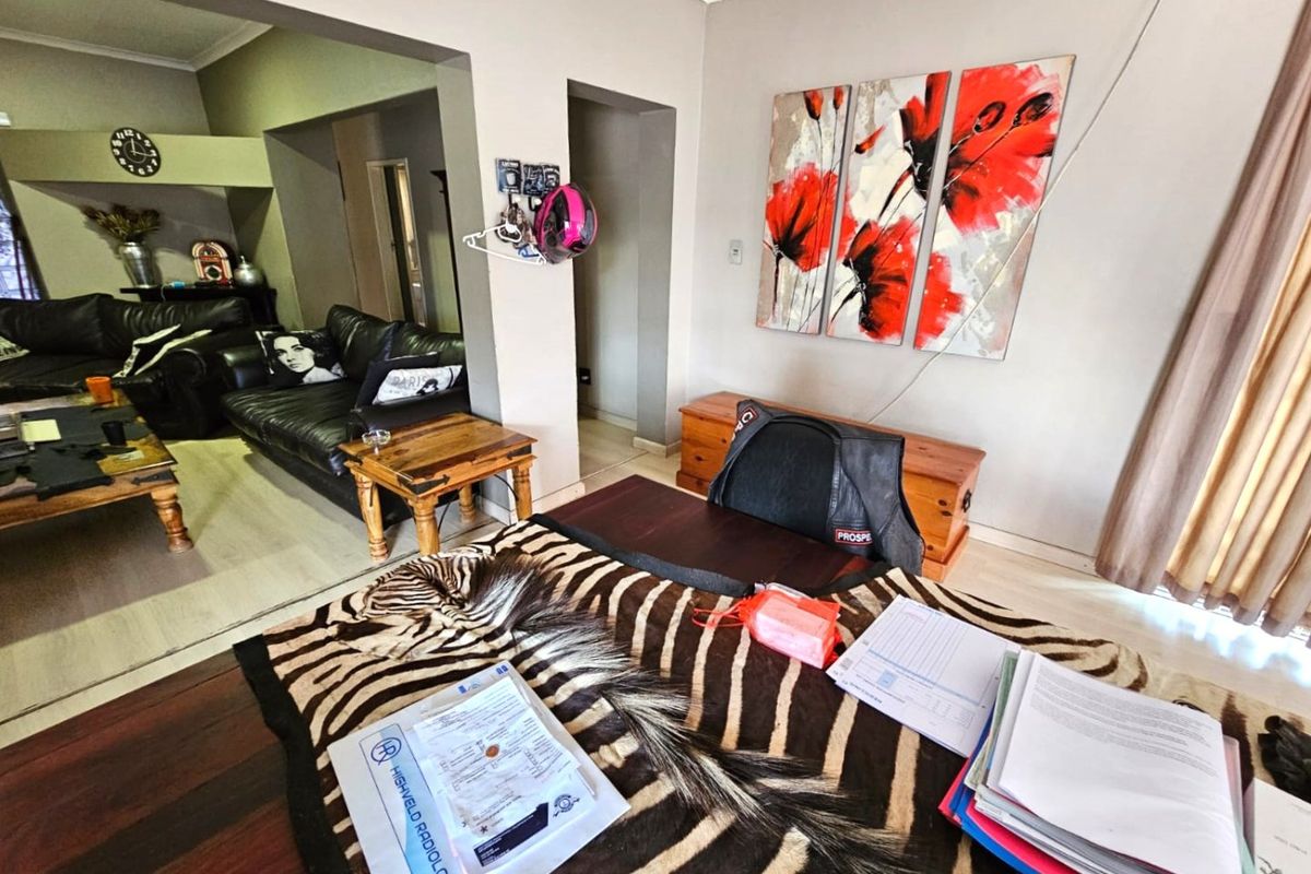 A living room area featuring neutral wall tones, cove cornicing, and skirting boards, providing a functional space for relaxation and daily activities.