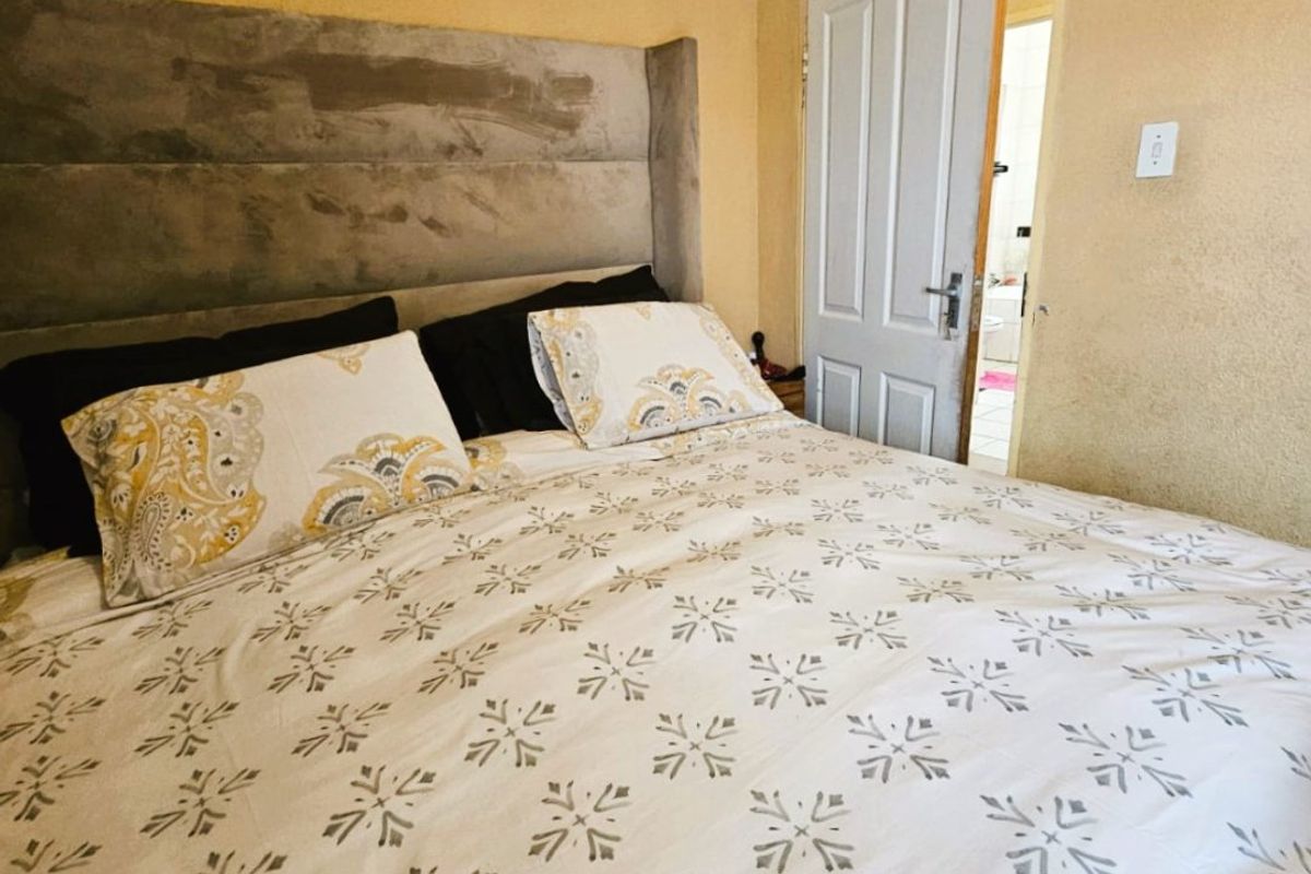 A bedroom featuring a built-in headboard and direct access to an adjoining bathroom.