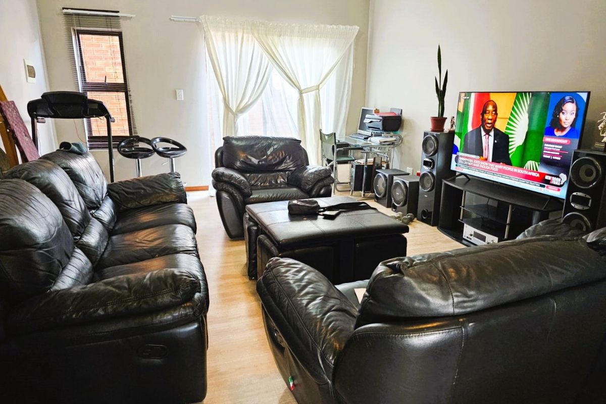 A living room featuring laminate flooring and a sliding glass door providing natural light.