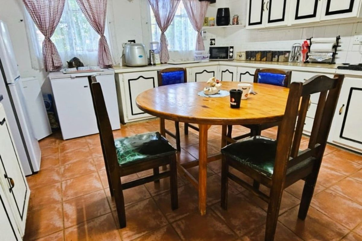 A functional kitchen featuring tiled flooring and built-in cabinetry, offering a traditional layout with potential for modern updates.