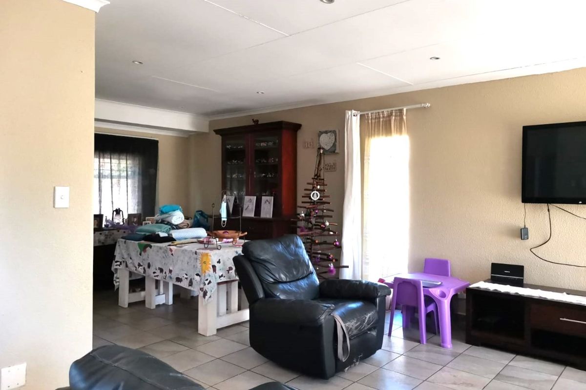 A spacious living area featuring tiled flooring and recessed downlighting, offering a versatile layout for family living and dining.