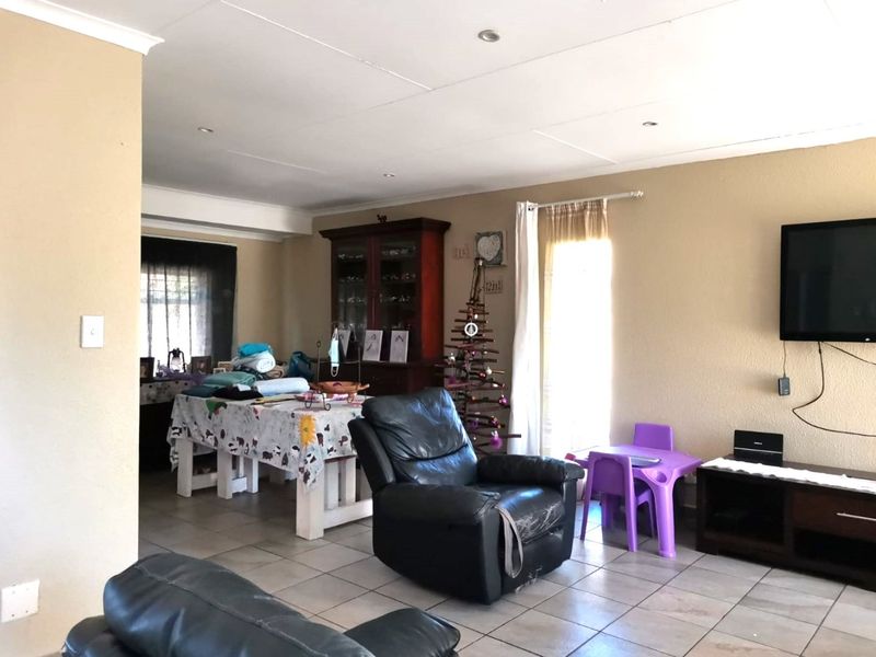 A spacious living area featuring tiled flooring and recessed downlighting, offering a versatile layout for family living and dining.