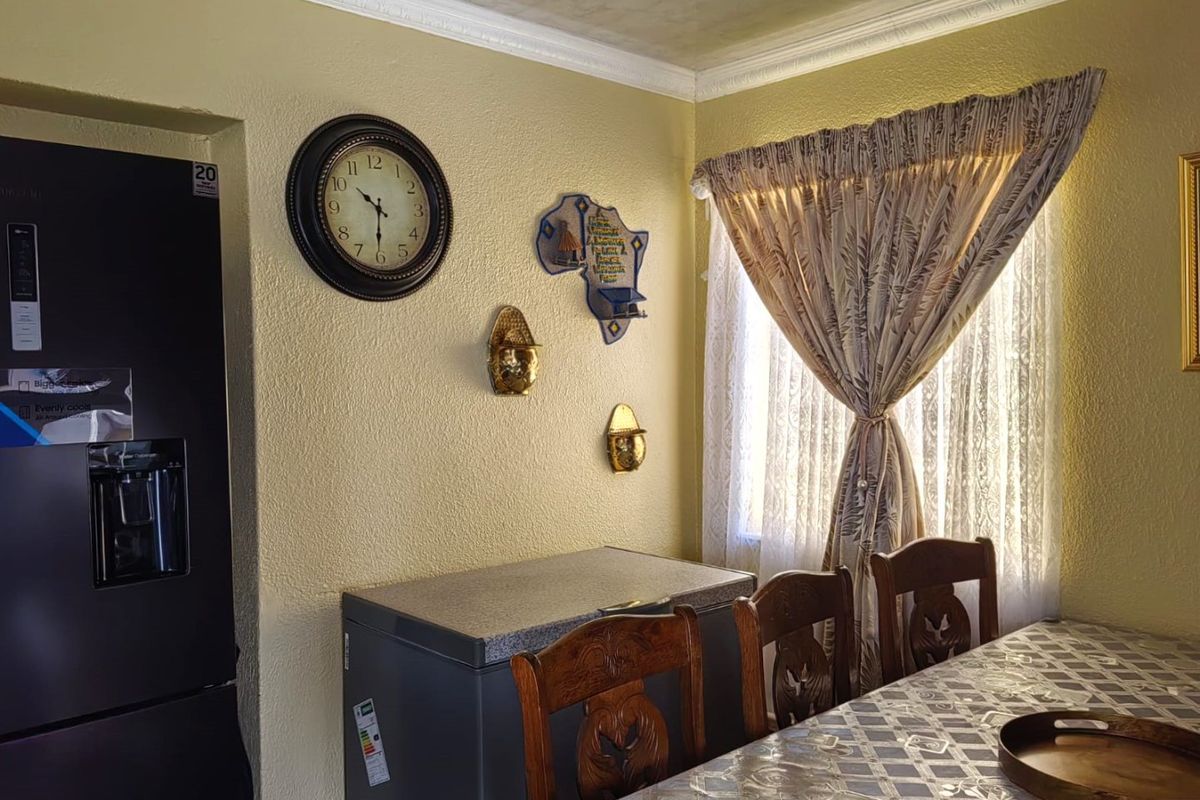 A kitchen area featuring textured walls, decorative cornice detailing, and a window with natural light.
