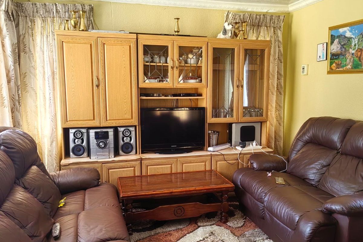 A traditional living room featuring built-in wooden cabinetry and decorative crown molding, providing a classic foundation for updated interior styling.