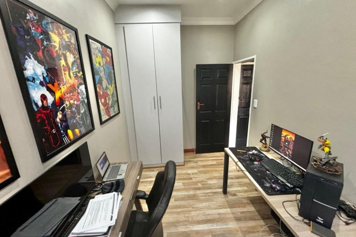 A functional bedroom or home office featuring built-in cabinetry, wood-look flooring, and recessed ceiling lighting.