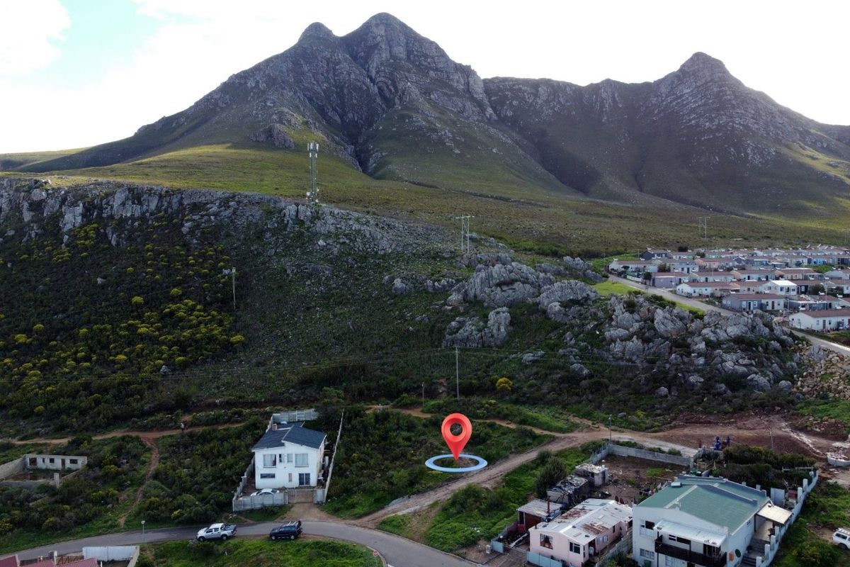 Aerial view of a vacant residential plot situated at the base of a mountain, offering scenic landscape views.