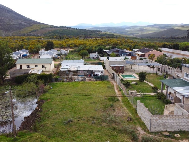 Aerial view of a residential property featuring a swimming pool, garden area, and surrounding neighborhood landscape.
