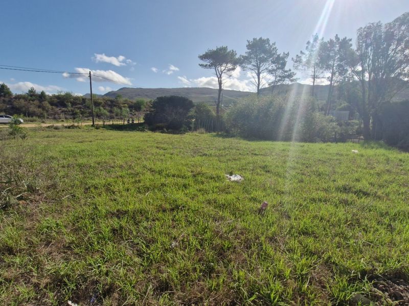 A vacant residential plot featuring open grassland, perimeter fencing, and scenic mountain views, suitable for future development.