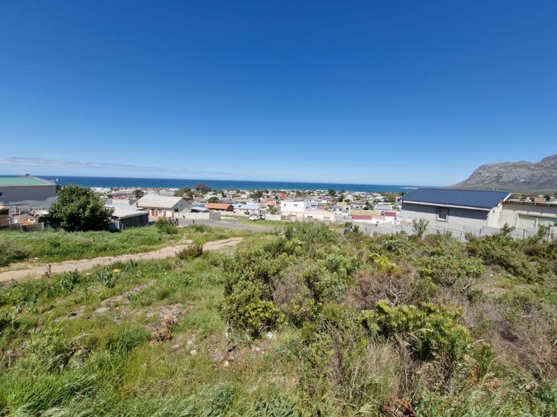 Elevated view overlooking the coastal residential area with a scenic mountain backdrop.