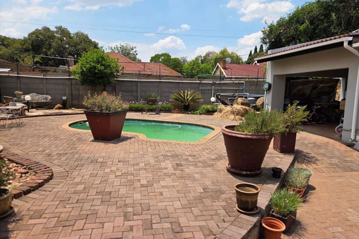 Outdoor pool area featuring a paved patio, swimming pool, and perimeter walling, providing a functional space for outdoor recreation and entertainment.