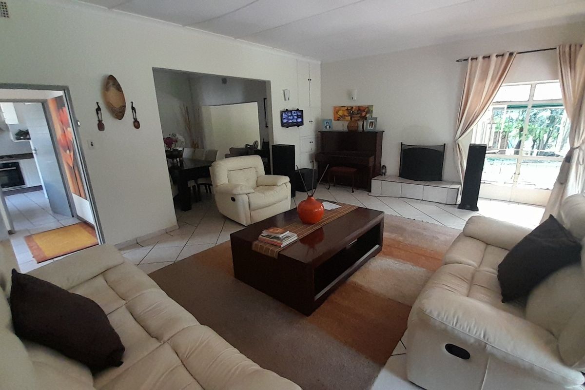Spacious living room featuring tiled flooring, a built-in fireplace, and direct access to the outdoor area through sliding glass doors.
