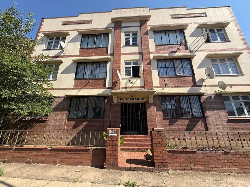 Front elevation of the Windermere apartment building, featuring a classic brick and plaster facade with secure gated entrance and multi-level window configuration.