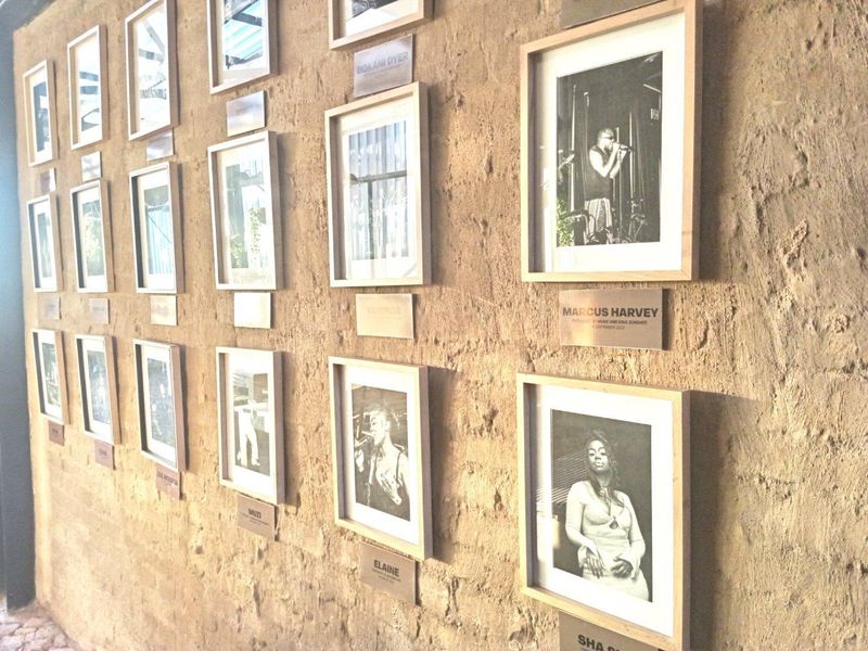 A hallway featuring a textured exposed stone wall decorated with a series of framed photographs.