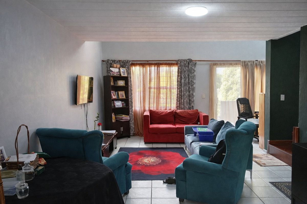 A spacious living room featuring tiled flooring, a ceiling light fixture, and a sliding glass door providing access to the exterior.