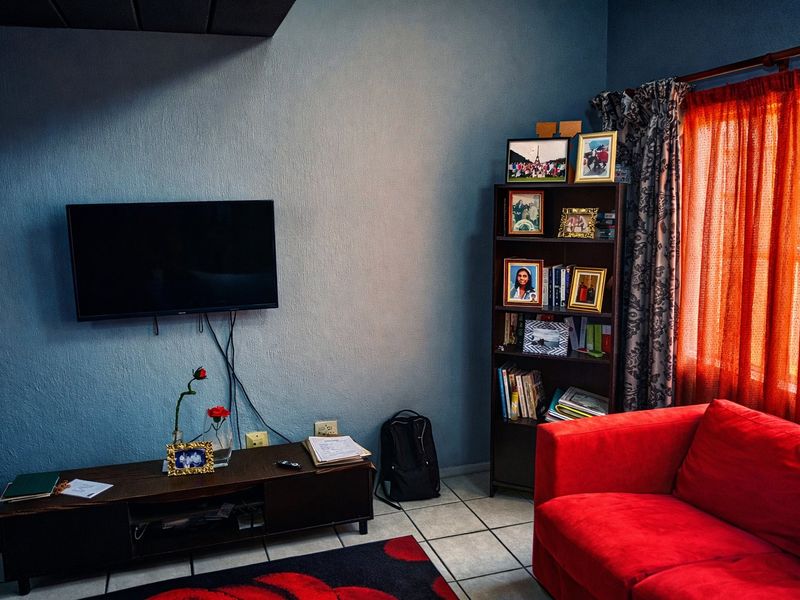 A living room area featuring tiled flooring and textured walls, providing a functional space for relaxation.